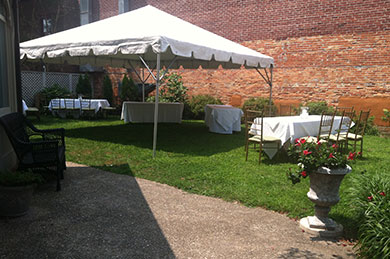 canopy tent with tables and chairs on lawn
