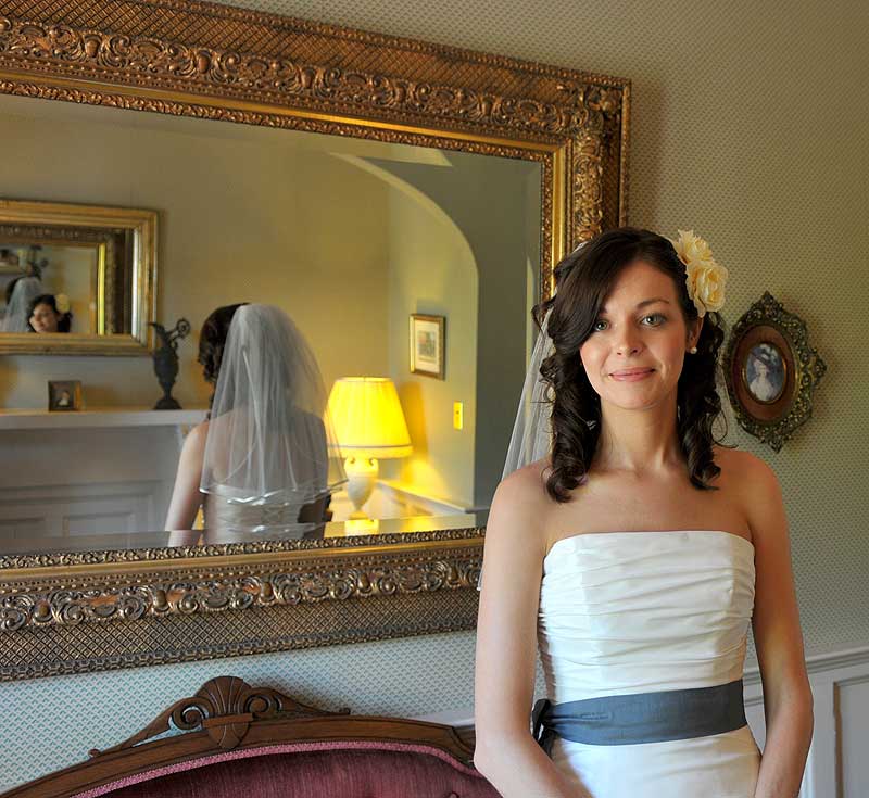 Bride standing infront of mirror in ladies parlor Atlantic Hotel