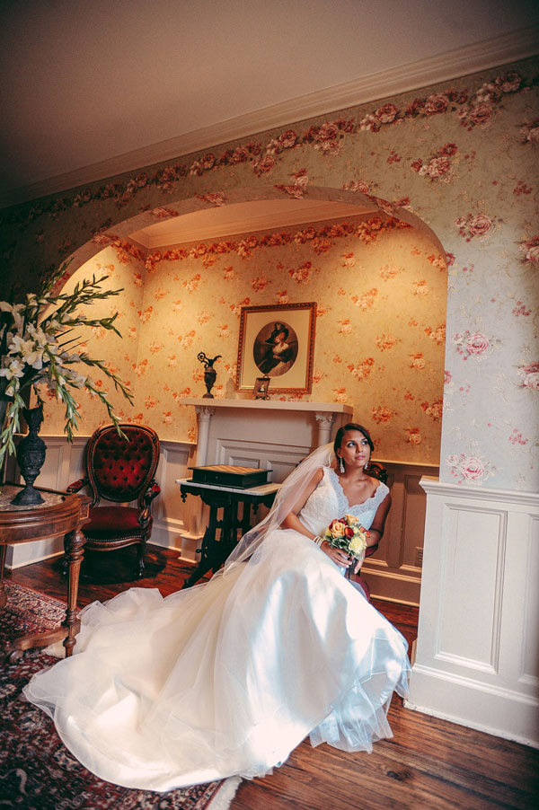 Bride sitting in chair in victorian room holding bouquet in berlin md