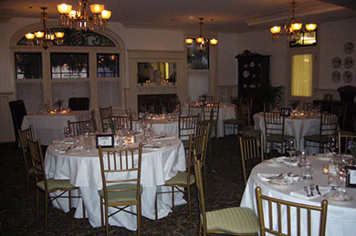 round tables and chairs set for dining in ballroom with chandeliers