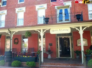 hotel brick exterior front porch with rocking chairs united states flag maryland flag flowers