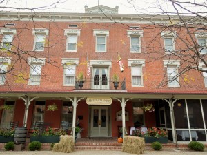 exterior of brick hotel during winter with flags hay pumpkins and chairs