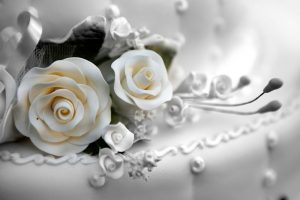close up of flowers on white wedding cake